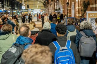 Foto van mensen die zich verzamelen rondom het Presence Choir bij Gospel at the Station in Nijmegen