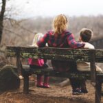 Unsplash afbeelding van vrouw met twee kinderen op een bankje in bosrijke omgeving