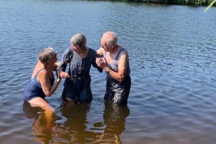 80-jarige man doopt zijn vrouw in natuurwater