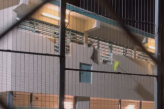 Screenshot van gevangenen die vanuit hun cel met doeken zwaaien en reageren op evangelisatie
