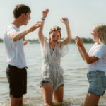 Jonge vrouw wordt gedoopt op strand Horst