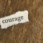 Afbeelding Unsplash van het woord 'courage' op een houten achtergrond