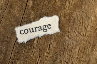 Afbeelding Unsplash van het woord 'courage' op een houten achtergrond