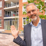 Frans de Lange, directeur GlobalRize, met op de achtergrond het nieuwe Zendingshuis
