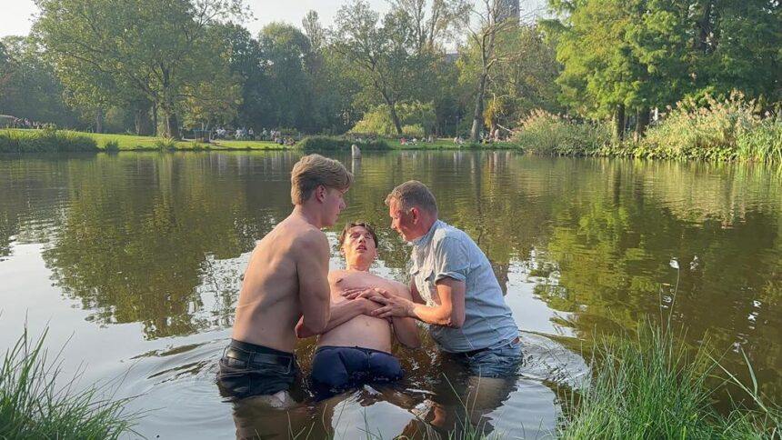 Jongen wordt gedoopt in het Vondelpark in Amsterdam